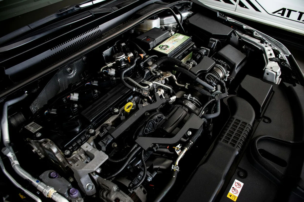 Close do motor de um carro mostrando o compartimento onde fica a bateria automotiva