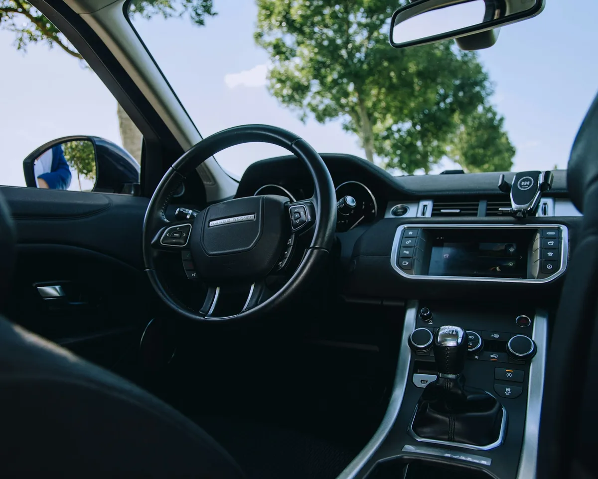 Painel e volante de carro, representando a perspectiva do motorista em uma descida