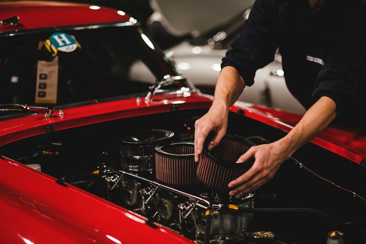 Compartimento do motor de um carro com o capô aberto, mostrando a área onde o filtro de ar fica instalado